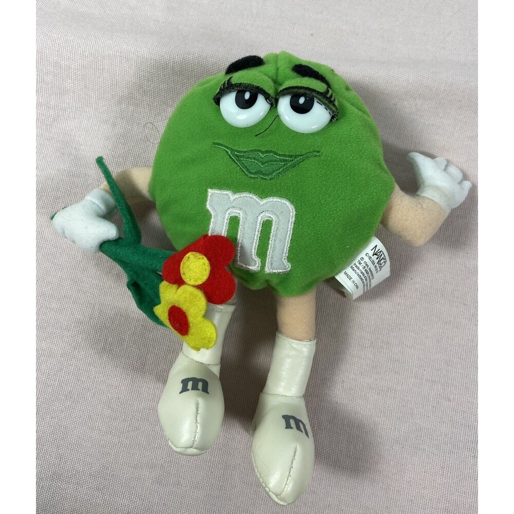 Nanco Plush Green M & M Doll With 3 Flowers.  7” Tall.  m&m with flowers